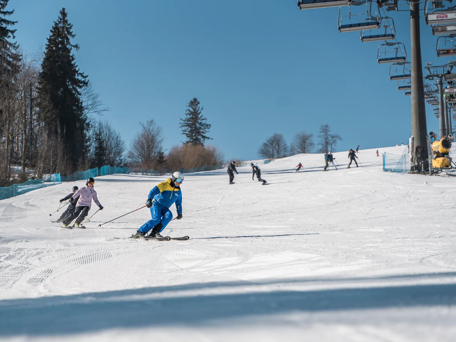 Narciarze zjeżdżający stokiem Witów Ski, obok kolej krzesełkowa