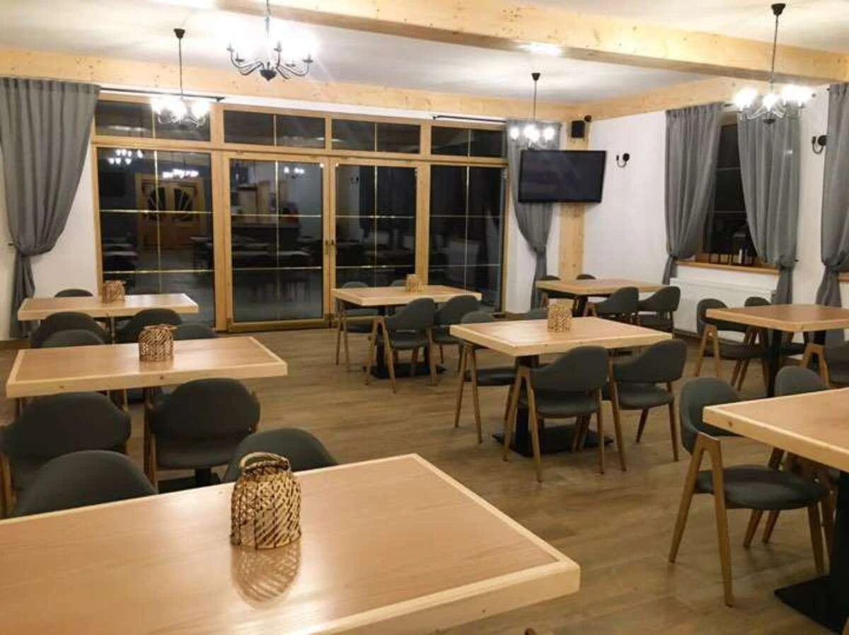 Sala restauracyjna Rezydencji Kojsówka ze stolikami i wyjściem na taras