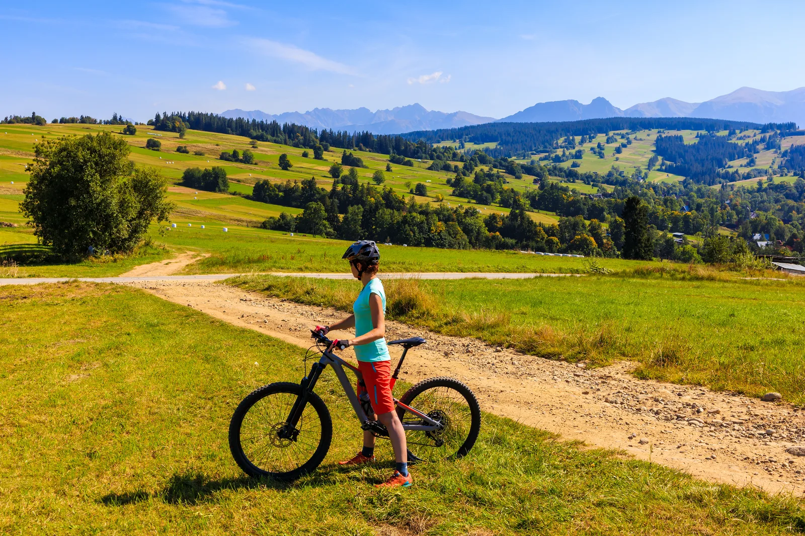 Rowerzystka na szutrowej drodze nad Witowem, w tle panorama Tatr